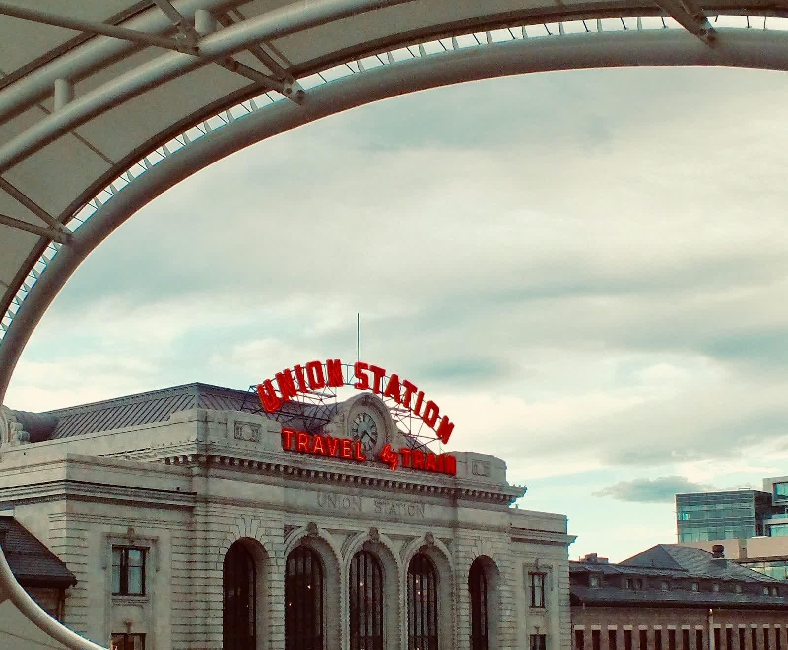 The Union Station sign in downtown Denver, with the city behind it