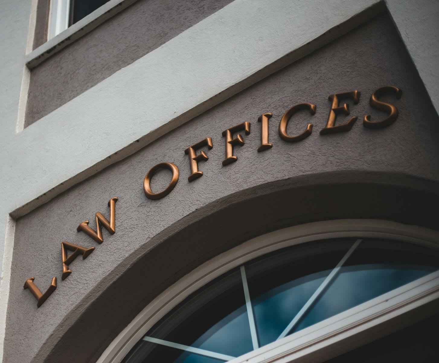 Brass LAW OFFICES lettering on the stone facade of a law firm building